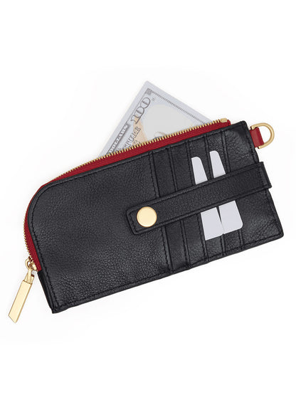 A black pebbled leather Hammitt Los Angeles 210 East Wallet in Black/Brushed Gold/Red Zip features gold accents and holds two visible cards along with a partially visible folded U.S. hundred-dollar bill, showcasing its sleek design.