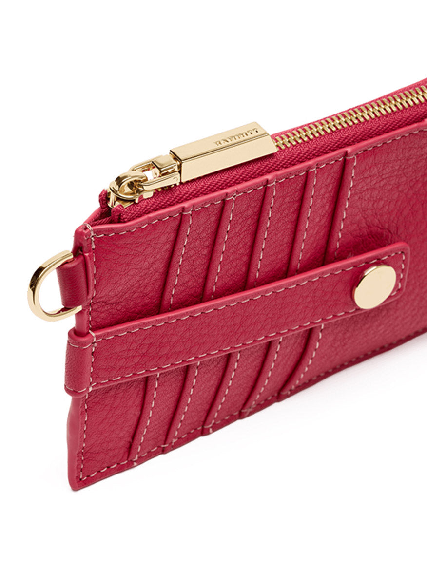 Close-up of the Hammitt Los Angeles 210 East Wallet in Calypso Pebble/Gold, a sleek women's wallet crafted from fuchsia pebbled leather with gold hardware, featuring card slots, a zippered pocket design, and a snap button detail.