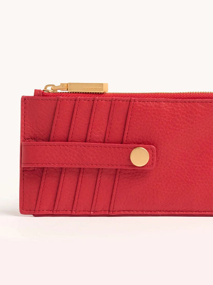 Close-up of the Hammitt Los Angeles 210 West Wallet in Poppy Red, featuring pebbled leather, a gold button, and zipper on a light background.