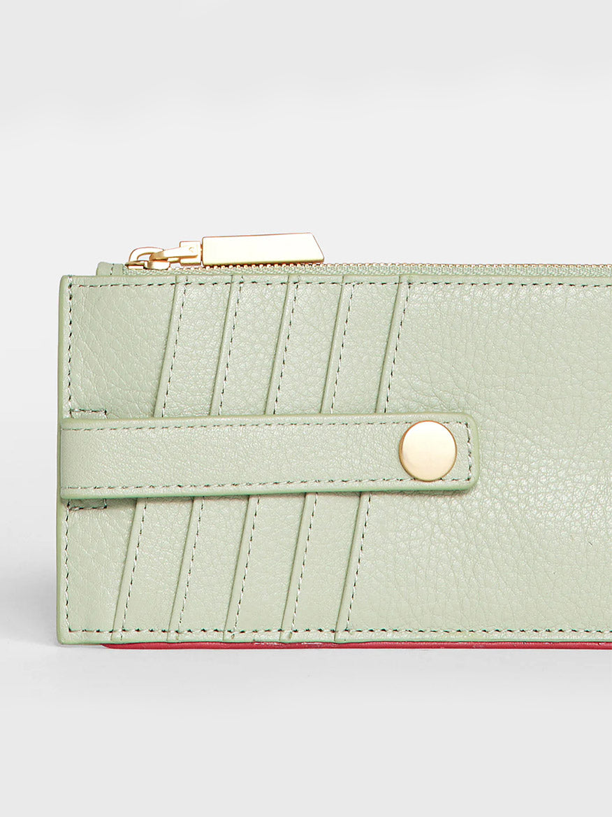 Hammitt Los Angeles 210 West Wallet in Cypress Sage with credit card slots, stitched detailing, a strap closure, and a gold-tone clasp, set against a white background.