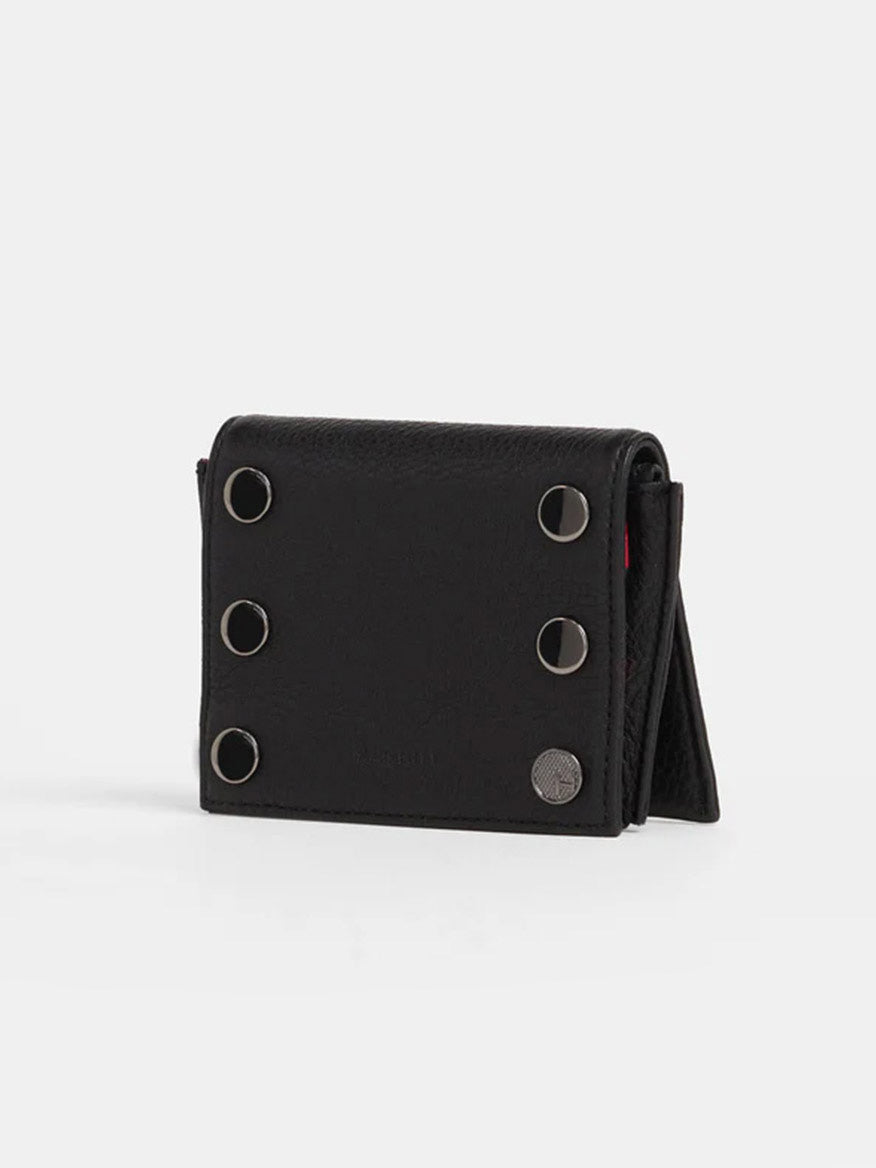 The Hammitt Los Angeles Allen Wallet in Black, crafted from luxurious pebbled leather, features four circular metal studs on the front and a fold-over design. It stands upright against a plain white background, highlighting its chic zippered main compartment.