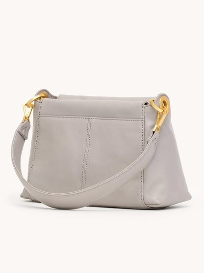 The Hammitt Los Angeles Bryant Medium Crossbody Bag in Stormy/Brushed Gold features a light gray finish, wide strap, gold-tone hardware, visible stitching, and two exterior slip pockets shown from the back.