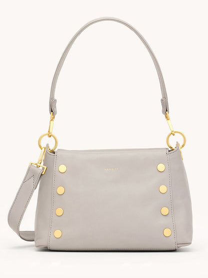 The Hammitt Los Angeles Bryant Medium Crossbody Bag in Stormy/Brushed Gold features light gray pebbled leather, gold studs, a detachable strap, and a short handle, shown against a plain background.