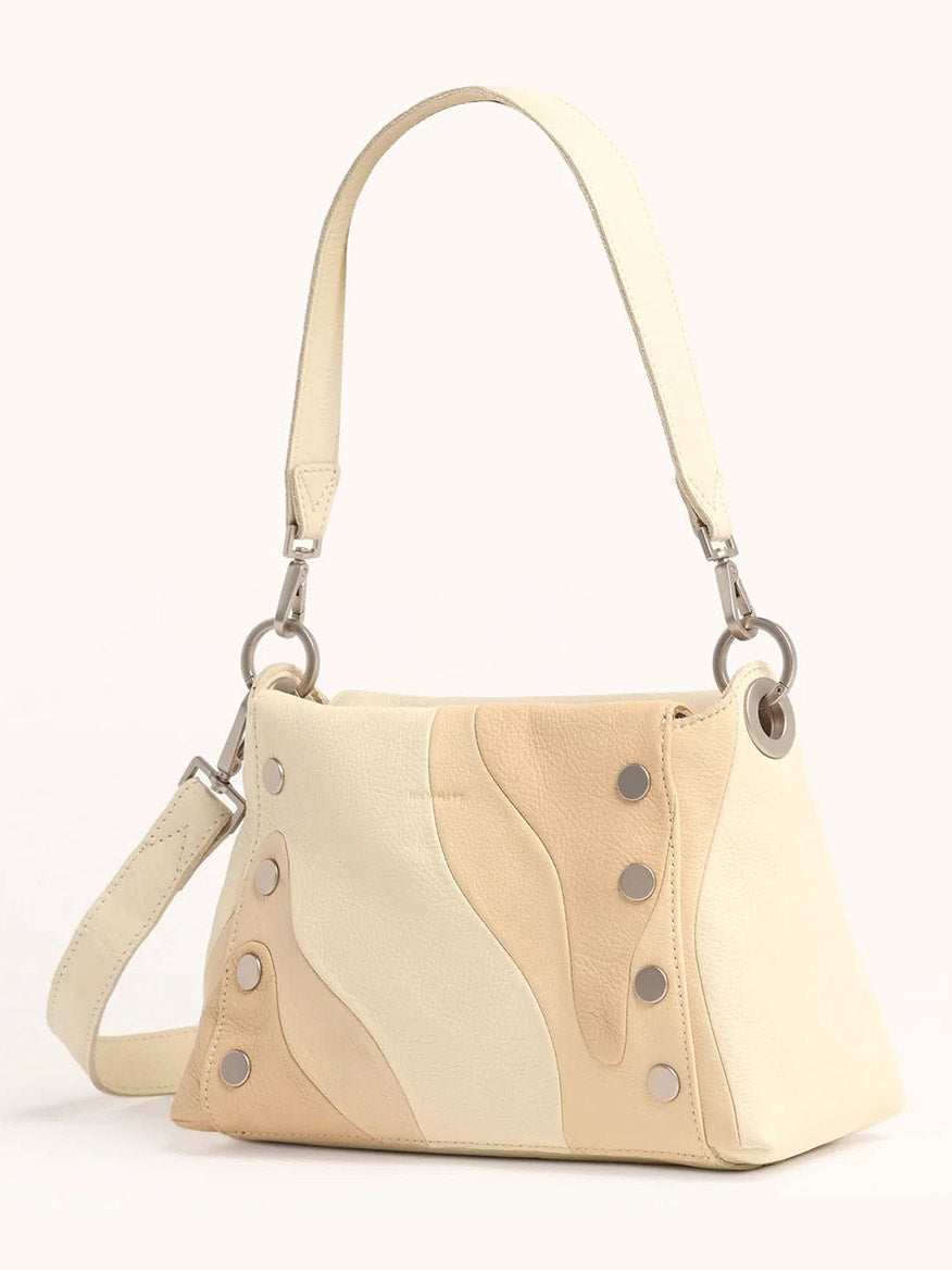 From the Coastal Cream collection, the Hammitt Los Angeles Bryant Medium Crossbody Bag features a cream and beige wavy pattern with silver rivets, a detachable shoulder strap for crossbody convenience, and a short handle for easy carrying.