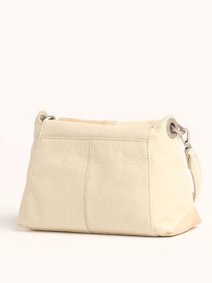 The Hammitt Los Angeles Bryant Medium Crossbody Bag in Coastal Cream is a beige leather handbag with a simple design and detachable strap, transitioning effortlessly from crossbody to shoulder bag, perfect against a light background.