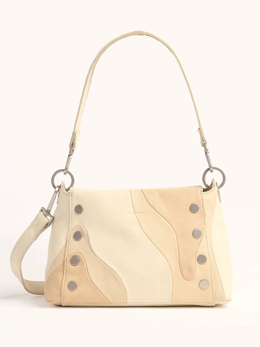 The Hammitt Los Angeles Bryant Medium Crossbody Bag in Coastal Cream is a versatile beige leather handbag with a wavy pattern, metal ring attachments, and decorative studs. It transforms effortlessly from a crossbody to a shoulder bag, adding elegance to any outfit.