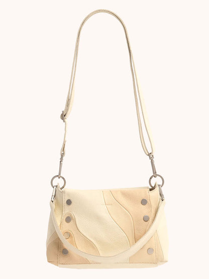 The Hammitt Los Angeles Bryant Medium Crossbody Bag in Coastal Cream boasts a wave pattern, silver studs, and a long adjustable strap. Its versatile design allows it to be used as both a crossbody and shoulder bag.