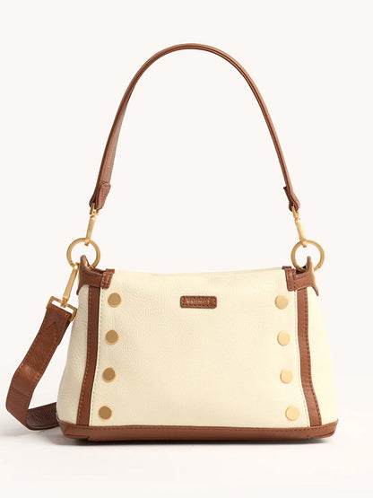 The Hammitt Los Angeles Bryant Medium Crossbody Bag in Courtyard Cream is a cream pebbled leather shoulder bag with brown trim, gold hardware, a detachable strap, and decorative gold studs on the front.