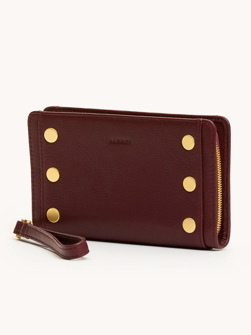 The Hammitt Los Angeles Bryant Wallet in Cherrywood Pebble/Brushed Gold features four gold buttons, a wrist strap, and a bold yellow side zipper.