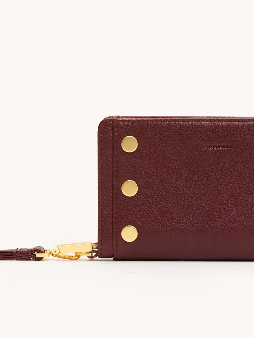The Hammitt Los Angeles Bryant Wallet in Cherrywood Pebble/Brushed Gold features three gold circular studs and a gold clasp on the left side, displayed against a plain background.