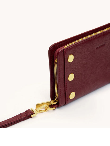 Close-up of the Hammitt Los Angeles Bryant Wallet in Cherrywood Pebble/Brushed Gold, featuring gold zipper, snap buttons, and a detachable wrist strap on a white background.