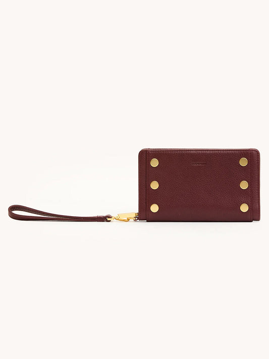 The Hammitt Los Angeles Bryant Wallet in Cherrywood Pebble/Brushed Gold features a maroon pebbled leather finish, gold button accents, and a detachable strap, shown against a plain light background.