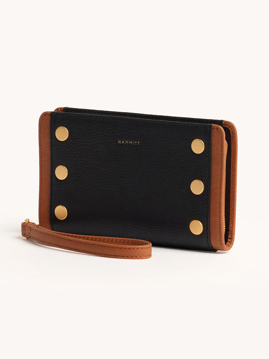 The Hammitt Los Angeles Bryant Wallet in North End showcases a sleek continental design with black and brown leather, gold studs, and a wrist strap, set against a light background.