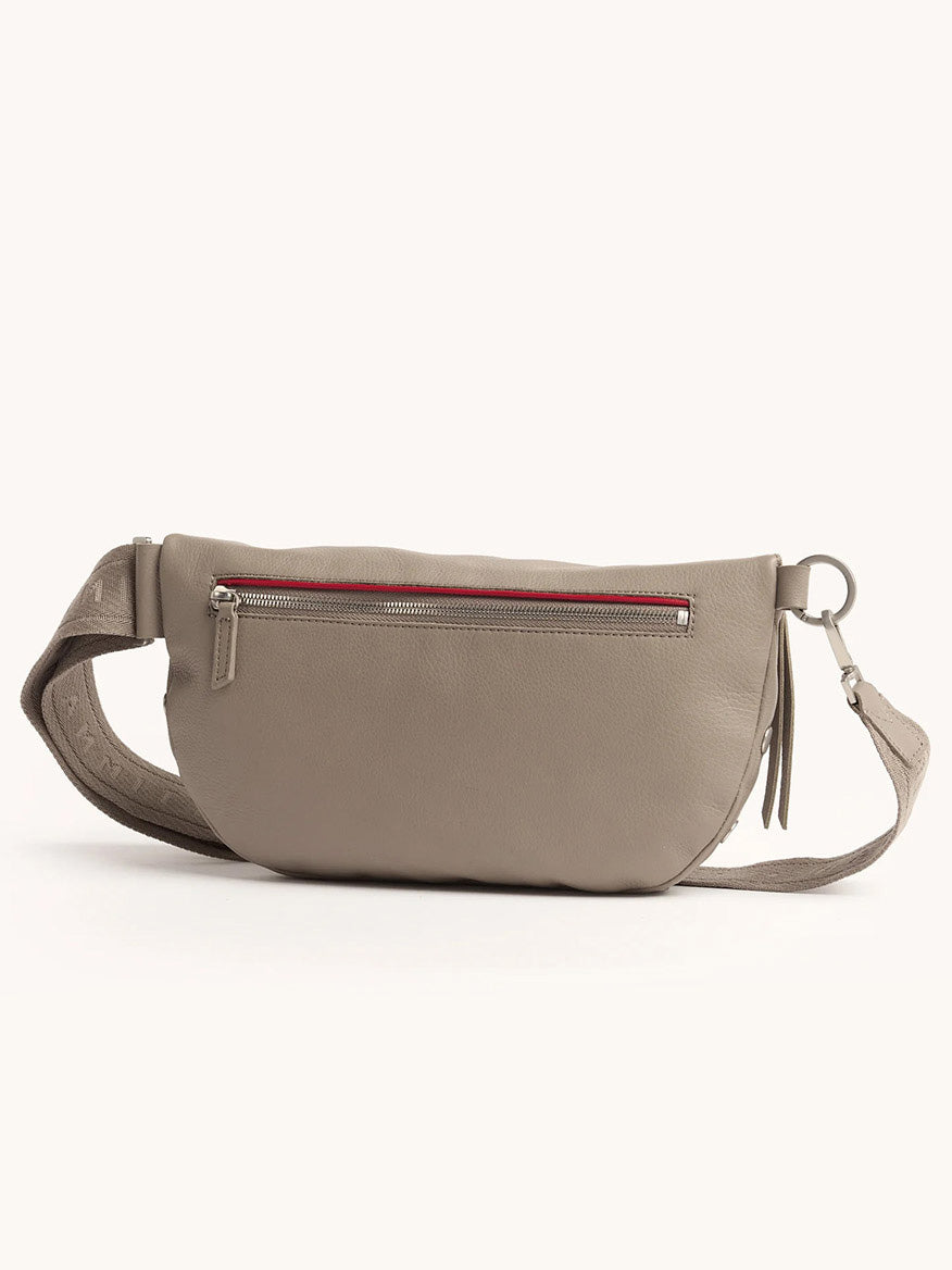 The Hammitt Los Angeles Charles Crossbody Large in Pewter Pebble/Brushed Silver features an adjustable strap, front zip pocket with red zipper accent, tassel detail, and can also be worn as a belt bag for hands-free convenience.
