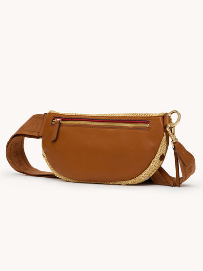 The Hammitt Los Angeles Charles Crossbody Medium in Cocoa Raffia/Gold features brown pebbled leather, woven straw, a zippered front pocket, and an adjustable strap, shown against a plain light background.