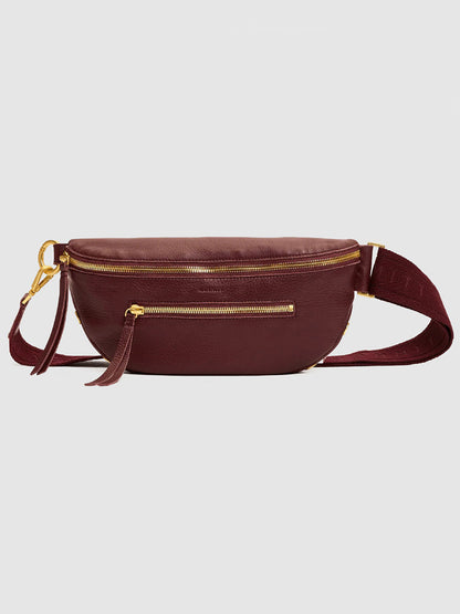 Featured against a plain light background, the Hammitt Los Angeles Charles Crossbody Medium in Cherrywood Pebble/Brushed Gold showcases maroon pebble leather, gold zippers, a front pocket, and an adjustable strap.