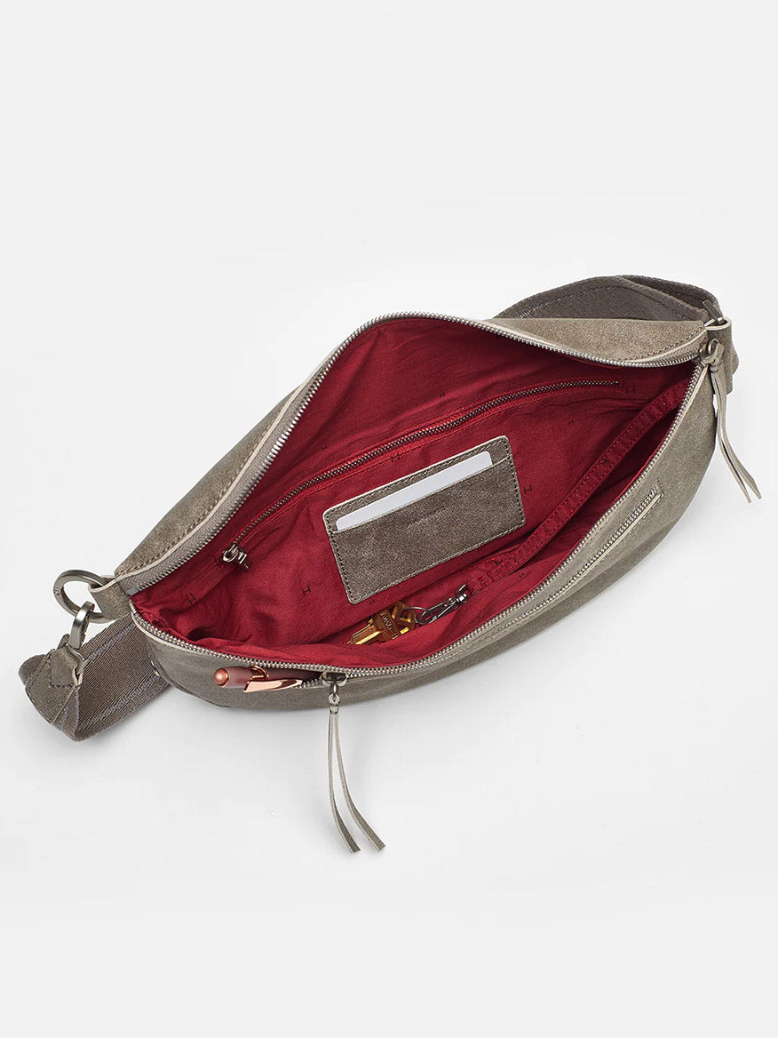 Open Hammitt Los Angeles Charles Crossbody Large in Pewter revealing a red interior with keys and coins inside, set against a white background.