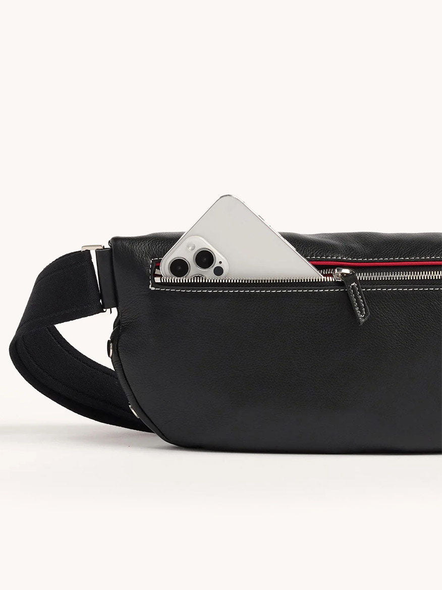 The Hammitt Los Angeles Charles Crossbody Large in Tempo Black is a leather bag with a partially open-zip pocket showing a smartphone inside and an adjustable strap for comfort.