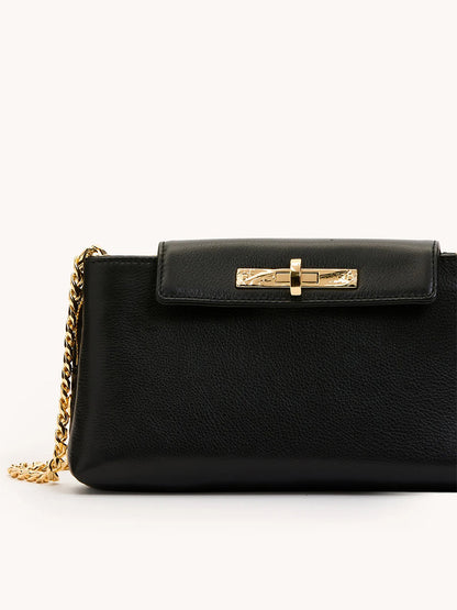 The Hammitt Los Angeles Charlotte Small in Black/Gold features black pebble leather, a gold chain strap, and a gold clasp on the front flap, displayed against a plain background.