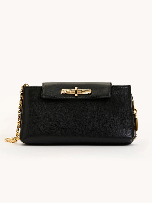 Hammitt Los Angeles Charlotte Small crossbody in black pebble leather features a gold chain strap and front flap with gold clasp, shown against a plain light background.