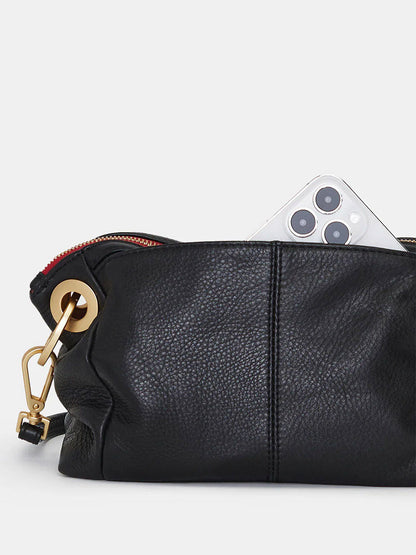 A sleek Hammitt Los Angeles Daniel Crossbody Clutch Small in Black & Brushed Gold, partially unzipped, shows a smartphone camera peeking out. Its gold clasp adds elegance to the versatile bag.