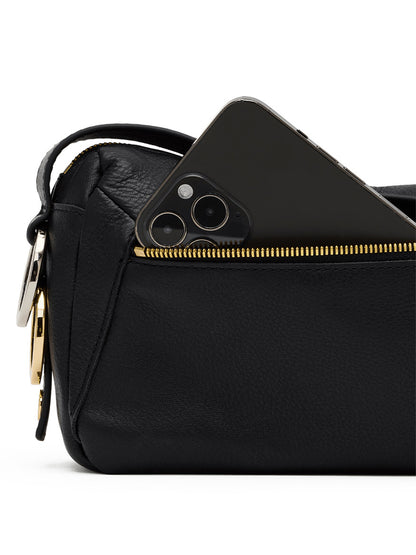 The Hammitt Los Angeles Doxie Medium in Black/Gold/Silver, featuring black pebbled leather and gold hardware, with a black smartphone partially visible in its front zippered pocket.