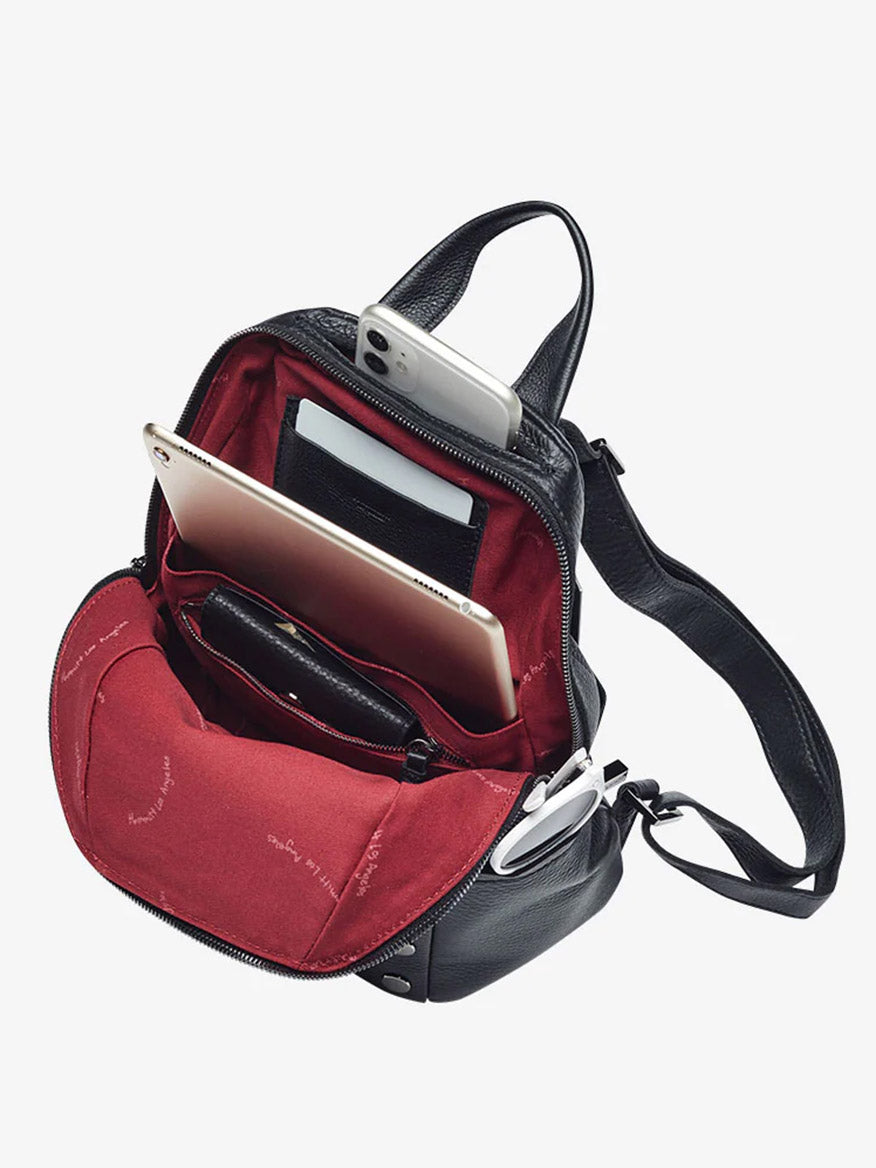 The Hammitt Los Angeles Hunter Medium Backpack in Black/Gunmetal features pebbled leather, a red interior, adjustable straps, and plenty of room for a tablet, smartphone, wallet, and earphones—perfect for daily use.