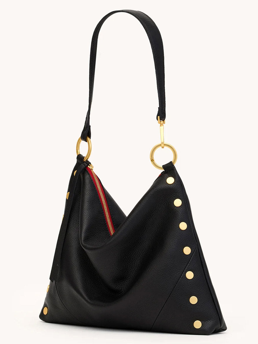 The Hammitt Los Angeles Kyle Large Shoulder Bag in Black/Brushed Gold & Red Zip features black pebble leather, gold studs on the sides, a single shoulder strap, gold ring hardware, and a slouchy triangular silhouette.