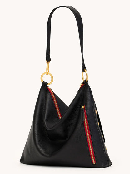 The Hammitt Los Angeles Kyle Large Shoulder Bag in Black/Brushed Gold & Red Zip features black pebble leather, a slouchy triangular shape, gold hardware, red-accented zippers, and a single shoulder strap for effortless sophistication.