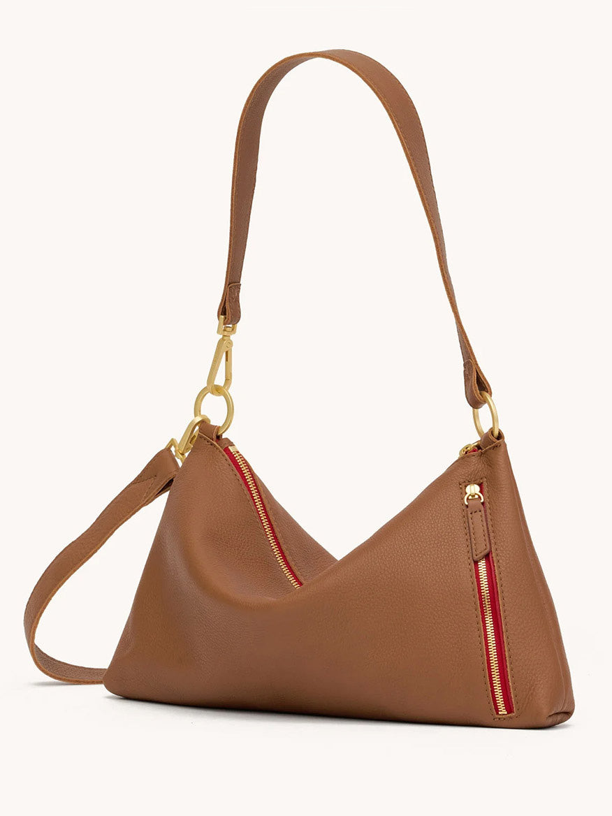 The Hammitt Los Angeles Kyle Medium Shoulder Bag in Mahogany Pebble features brushed gold hardware, two red zippered pockets, and an adjustable strap—ideal as a stylish crossbody or shoulder bag.