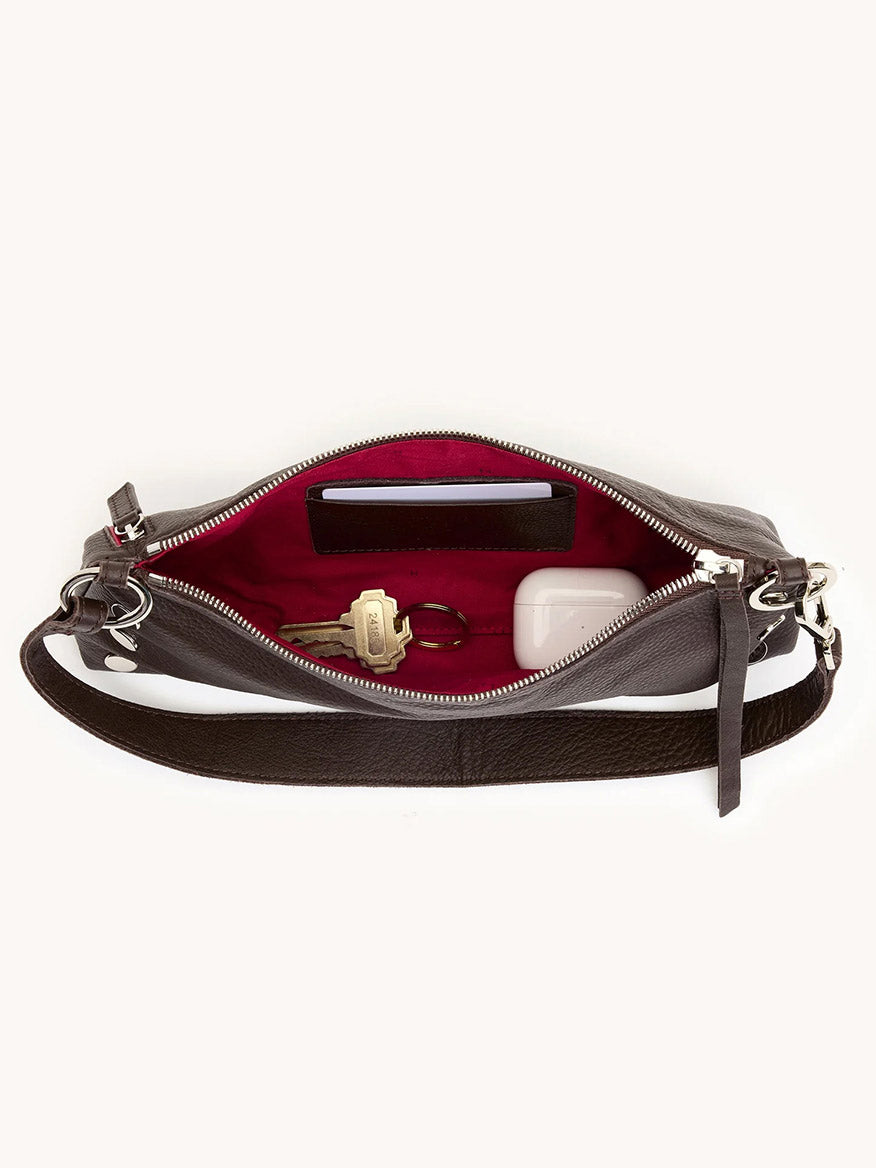 The Hammitt Los Angeles Kyle Shoulder Bag in Espresso Pebble/Silver is open, showing a red interior with a key, a white case, and a small card inside.
