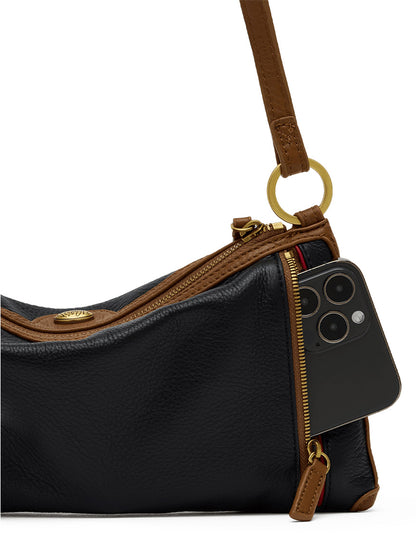 The Hammitt Los Angeles Kyle Shoulder Bag in East End/Antique Gold, crafted from black pebbled leather with brown accents, features a partially open gold zipper revealing a black smartphone inside its pocket.
