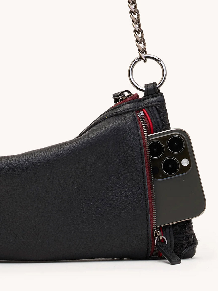 A Hammitt Los Angeles Kyle Shoulder Bag in Midnight Marquise/Gunmetal is partially open, revealing a smartphone with three camera lenses inside.