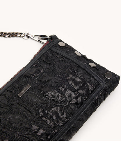 A close-up of the Hammitt Los Angeles Kyle Shoulder Bag in Midnight Marquise/Gunmetal, featuring black jacquard with a lace texture, metal studs, a zipper, and a partially visible chain strap.