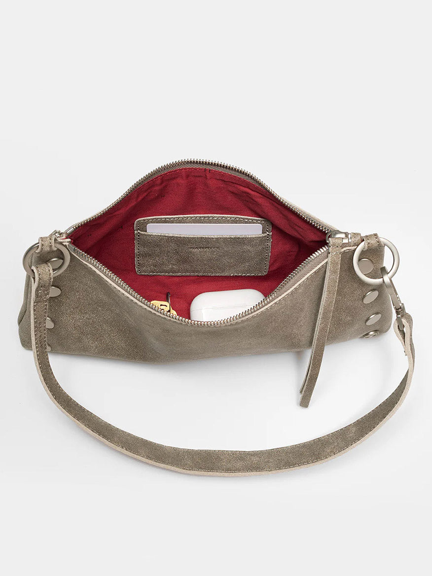 A Hammitt Los Angeles Kyle Shoulder Bag in Pewter with a zipper partially open, displaying a red interior with items including a phone, cards, and white earbuds. The fresh bag features a stylish crossbody strap for easy carrying.