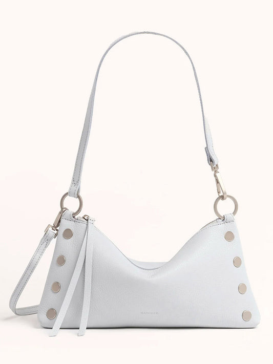 The Hammitt Los Angeles Kyle Shoulder Bag in Bluebird is a light blue handbag made from pebbled leather with silver studs on the sides, featuring an adjustable shoulder strap and two hanging leather accents for added charm.