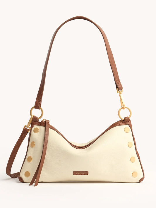 The Hammitt Los Angeles Kyle Shoulder Bag in Courtyard Cream features cream pebbled leather, brown straps, gold-tone side studs, a front brand label, and an optional crossbody strap, shown against a plain background.