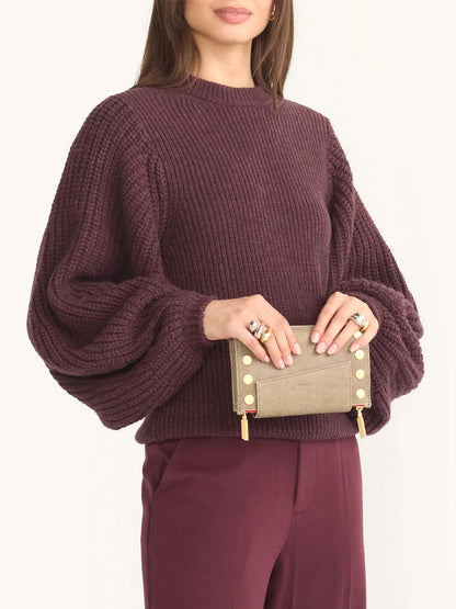 A person wears a knitted plum sweater with balloon sleeves, matching pants, and holds a Hammitt Los Angeles Levy Clutch in Pewter with a removable adjustable strap.