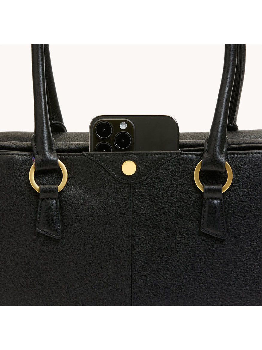 A black smartphone peeks from the outer pocket of the Hammitt Los Angeles Meredith Medium in Black/Brushed Gold, featuring gold hardware and double handles that enhance its chic, doctor-style bowling bag silhouette.