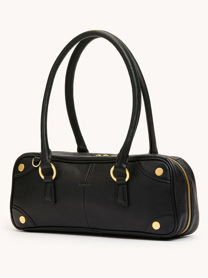 The Hammitt Los Angeles Meredith Small in Black/Brushed Gold is a black pebble leather doctor-style bowling bag featuring gold hardware, dual handles, rounded edges, and a zippered closure, displayed against a plain background.