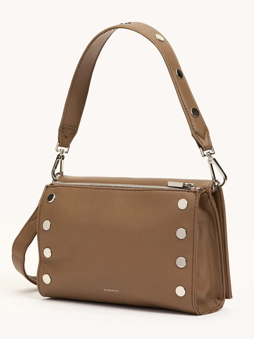 The Hammitt Los Angeles Montana Clutch Sml in Dune/Silver is a vintage-inspired tan leather handbag with a top handle, silver hardware, and decorative metal studs on the side.