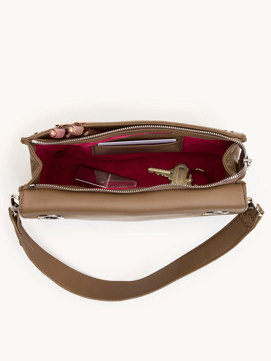 The Hammitt Los Angeles Montana Clutch Sml in Dune/Silver is a tan leather crossbody bag with a wide strap and red interior, perfect for carrying your smartphone, lipstick, and keys in vintage-inspired style.