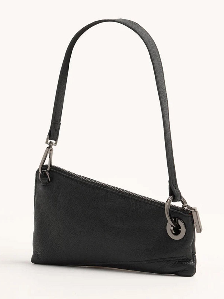 The Hammitt Los Angeles Nash Pochette in Black/Gunmetal is an asymmetrical handbag made from pebbled leather, featuring circular metal accents, a single strap, and a zipper closure.