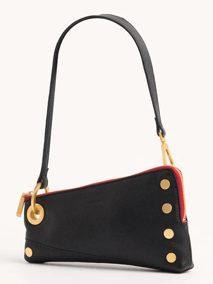 The Hammitt Los Angeles Nash Pochette in Black/Brushed Gold & Red Zip is a black leather handbag crafted from pebbled leather, featuring a red zipper and gold metal accents such as a ring and circular rivets. It comes with a thin shoulder strap attached to the bag.