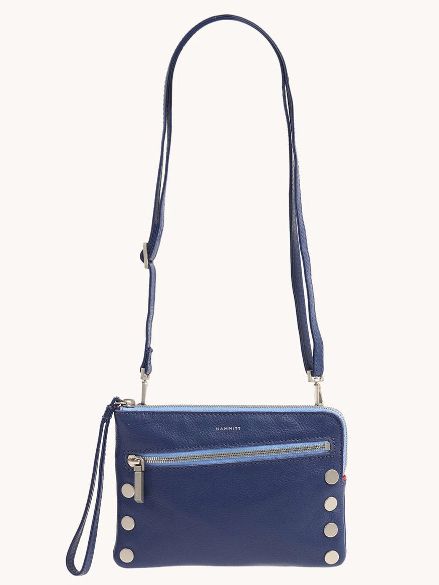 The Hammitt Los Angeles Nash Small Clutch in Jazz Blues is a blue pebbled leather crossbody bag with a front zipper pocket, circular metal studs on the lower front, and a convertible strap for versatile wear.