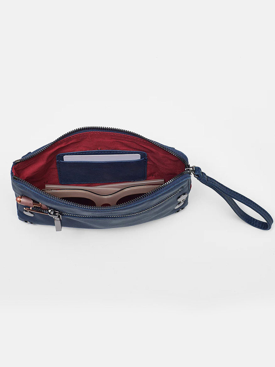 Open Hammitt Los Angeles Nash Small Clutch in Vintage Navy wristlet with a red interior on a white background.