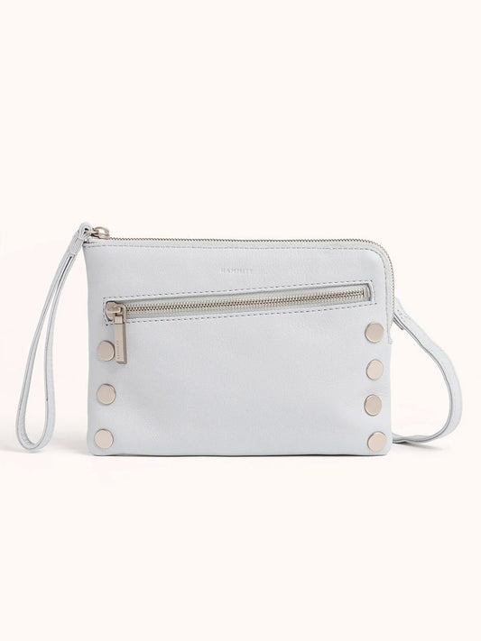 The Hammitt Los Angeles Nash Small Clutch in Bluebird is a pastel pebbled leather bag with a front zippered pocket and six metal studs. It features a wrist strap for easy conversion to a crossbody wristlet belt bag, offering versatile styling options.