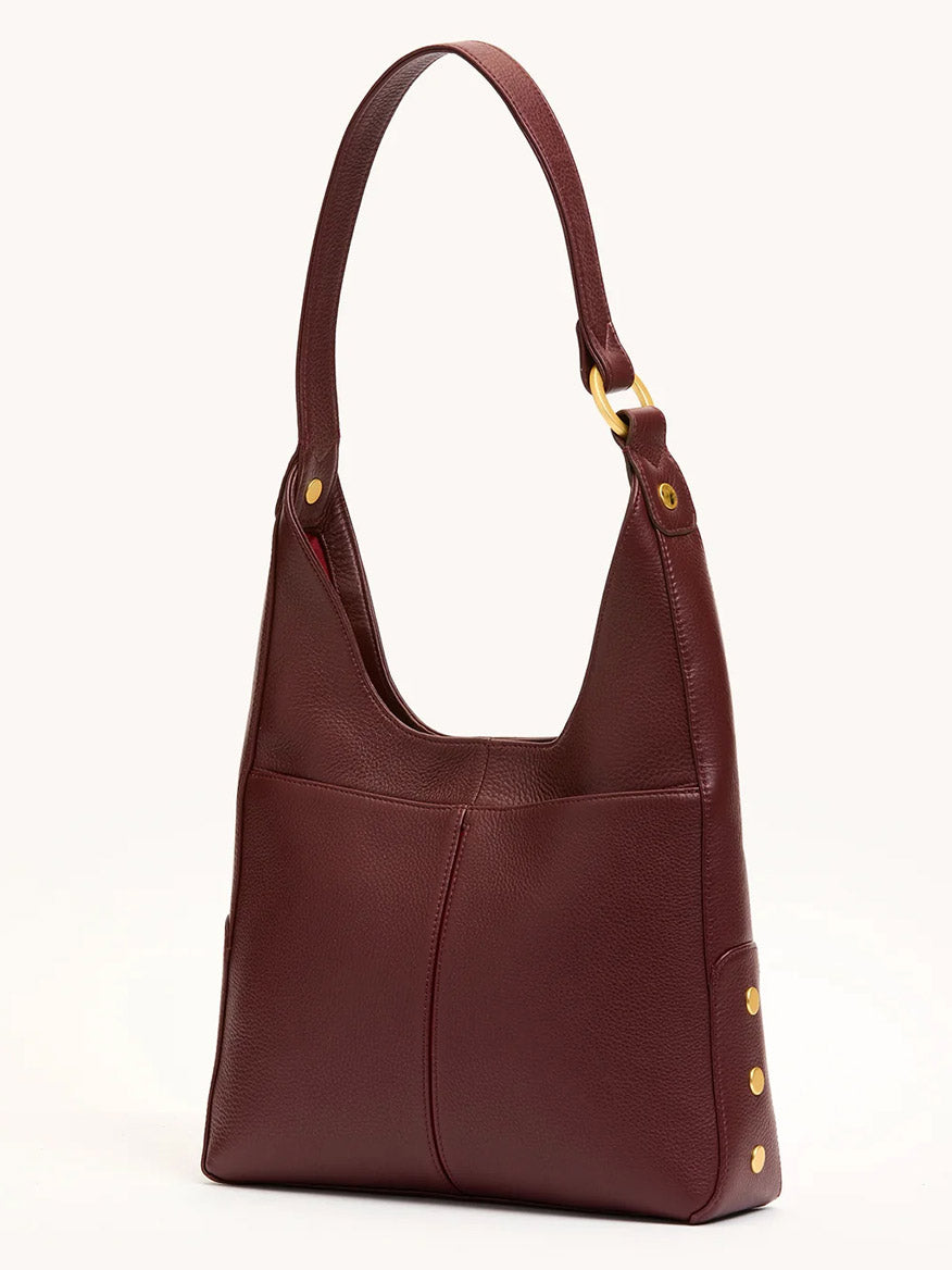 The Hammitt Los Angeles Tim Med Hobo in Cherrywood Pebble with brushed gold hardware and a wide strap is showcased on a neutral background, highlighting its stylish front stitching detail.