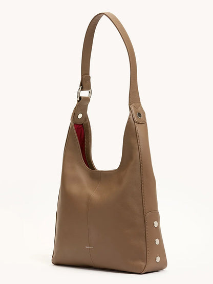 The Hammitt Los Angeles Tim Med Hobo in Dune/Silver features a dune brown leather design, single strap, silver rivet accents on the sides, and a peek of red lining inside.