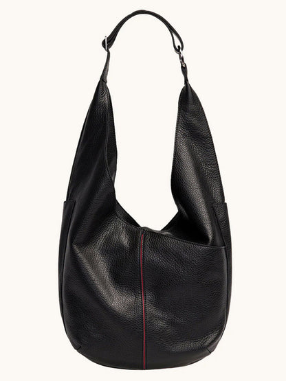 The Hammitt Los Angeles Tom Zip Large in Black/Gunmetal is a spacious black pebbled leather shoulder bag with a single wide strap, textured surface, and a subtle vertical red seam on the front.